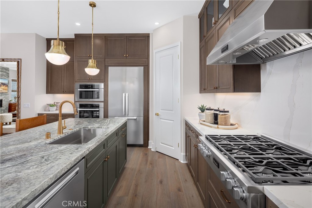 22085 Manarola Way Walnut, CA 91789 - Photo 12 of 20 a kitchen with granite countertop stainless steel appliances a sink a stove and a wooden floors