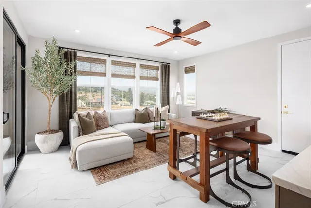 a living room with furniture a large window and a table