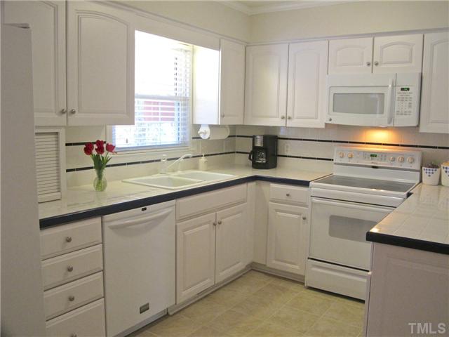 6509 Dew Drop Court Raleigh, NC 27613 - Photo 10 of 25 a kitchen with white cabinets and white appliances