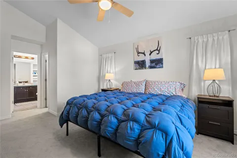 a bedroom with a bed and a lamp on dresser