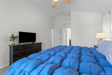 a bedroom with a bed and a flat tv screen on dresser