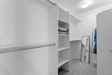 a view of walk in closet with clothes and shoes