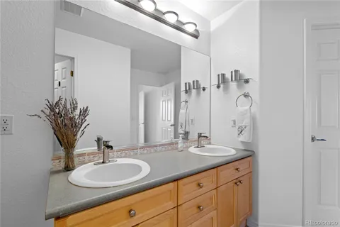 a bathroom with a granite countertop sink a mirror and shower
