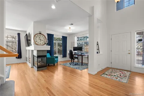 a living room with fireplace furniture and a wooden floor