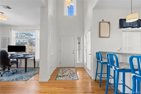 a view of dining room and livingroom with furniture wooden floor a rug and a painting