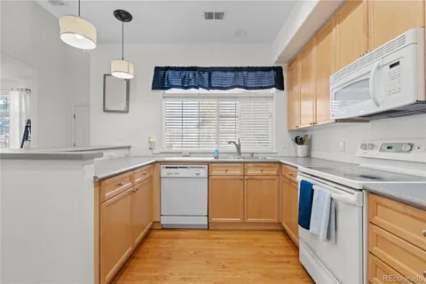 a kitchen with granite countertop a sink stove and cabinets