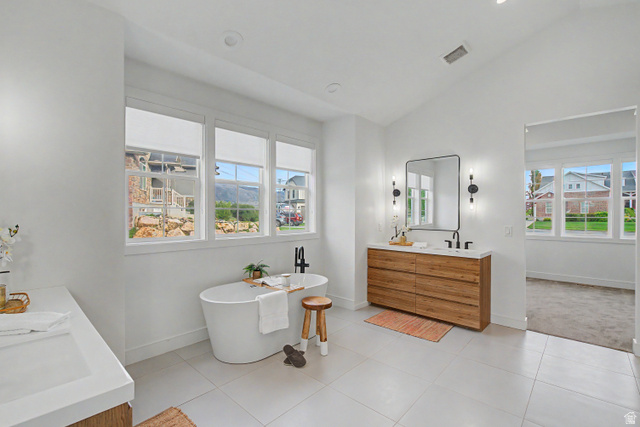 1952 South Comanche Circle Farmington, UT 84025 - Photo 26 of 52 Bathroom featuring double vanity, lofted ceiling, a freestanding tub, recessed lighting, and light tile patterned floors
