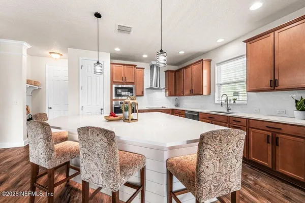a kitchen with granite countertop a table chairs stove a sink dishwasher and cabinets