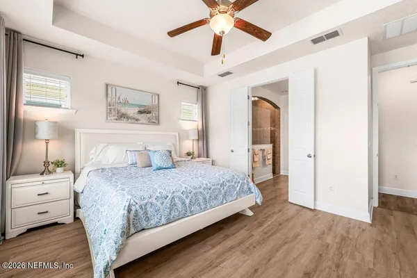 a bedroom with a large bed and a chandelier