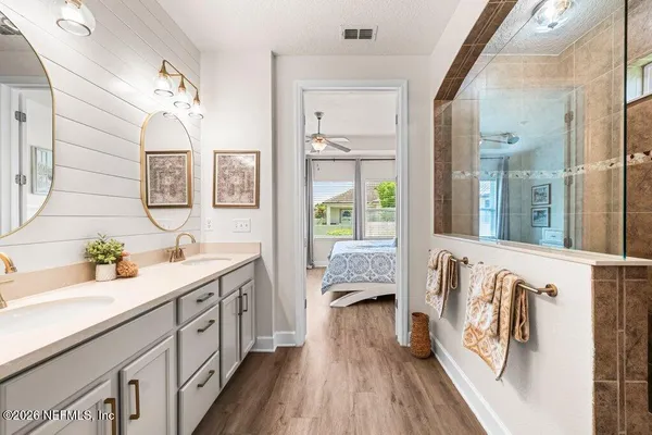 a spacious bathroom with a double vanity sink a mirror and a bathtub
