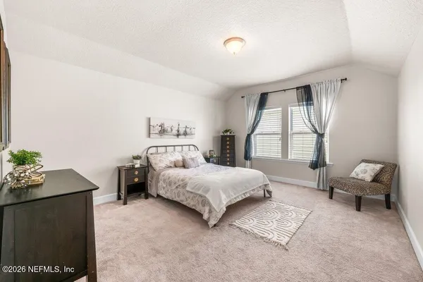 a bedroom with a bed chair and window