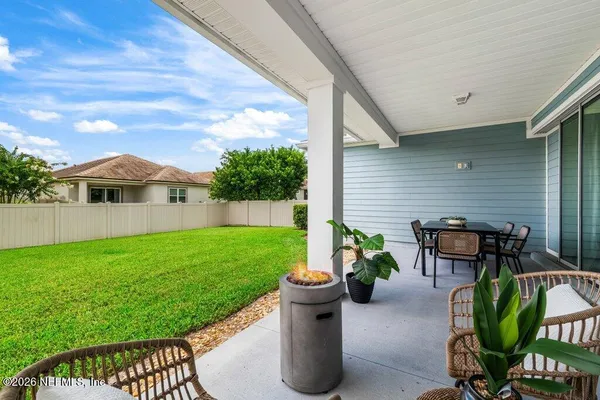 a view of a patio with table and chairs potted plants with wooden fence