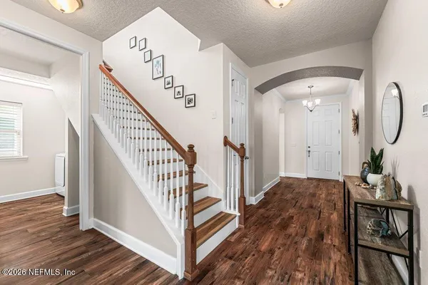 a view of a hallway with wooden floor and staircase