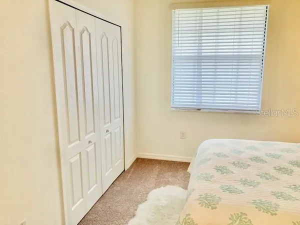 a view of a bedroom with a bed and a window