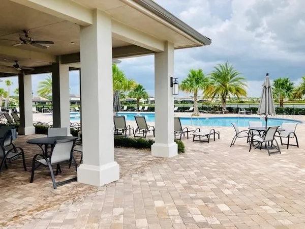 a living room with patio furniture and a floor to ceiling window