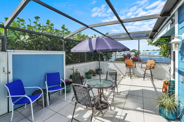 a view of a patio with a table and chairs under an umbrella