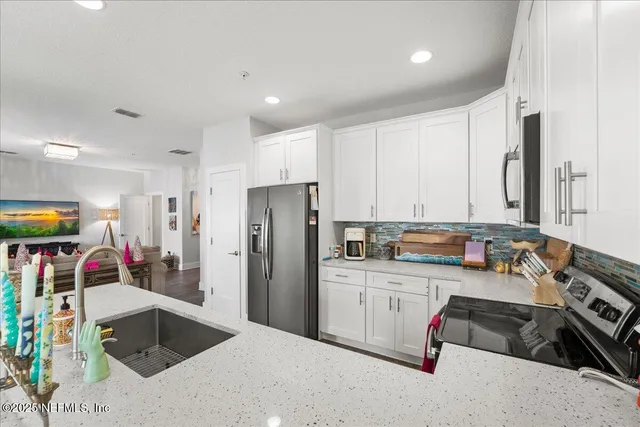 a kitchen with stainless steel appliances granite countertop a refrigerator sink and stove