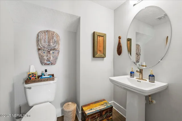 a bathroom with a toilet a sink and mirror