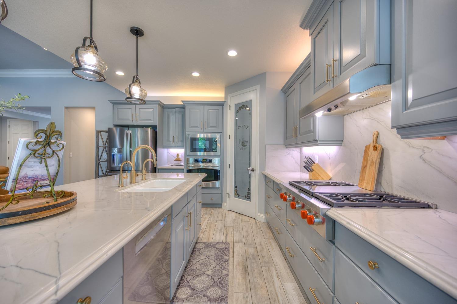 3731 Serena Avenue Clovis, CA 93619 - Photo 15 of 54 a kitchen with stainless steel appliances granite countertop a sink a stove and a wooden floors