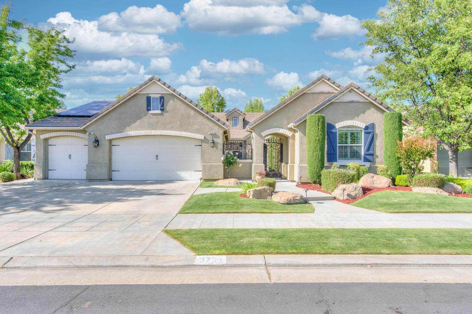 3731 Serena Avenue Clovis, CA 93619 - Photo 2 of 54 a front view of a house with a garden and trees
