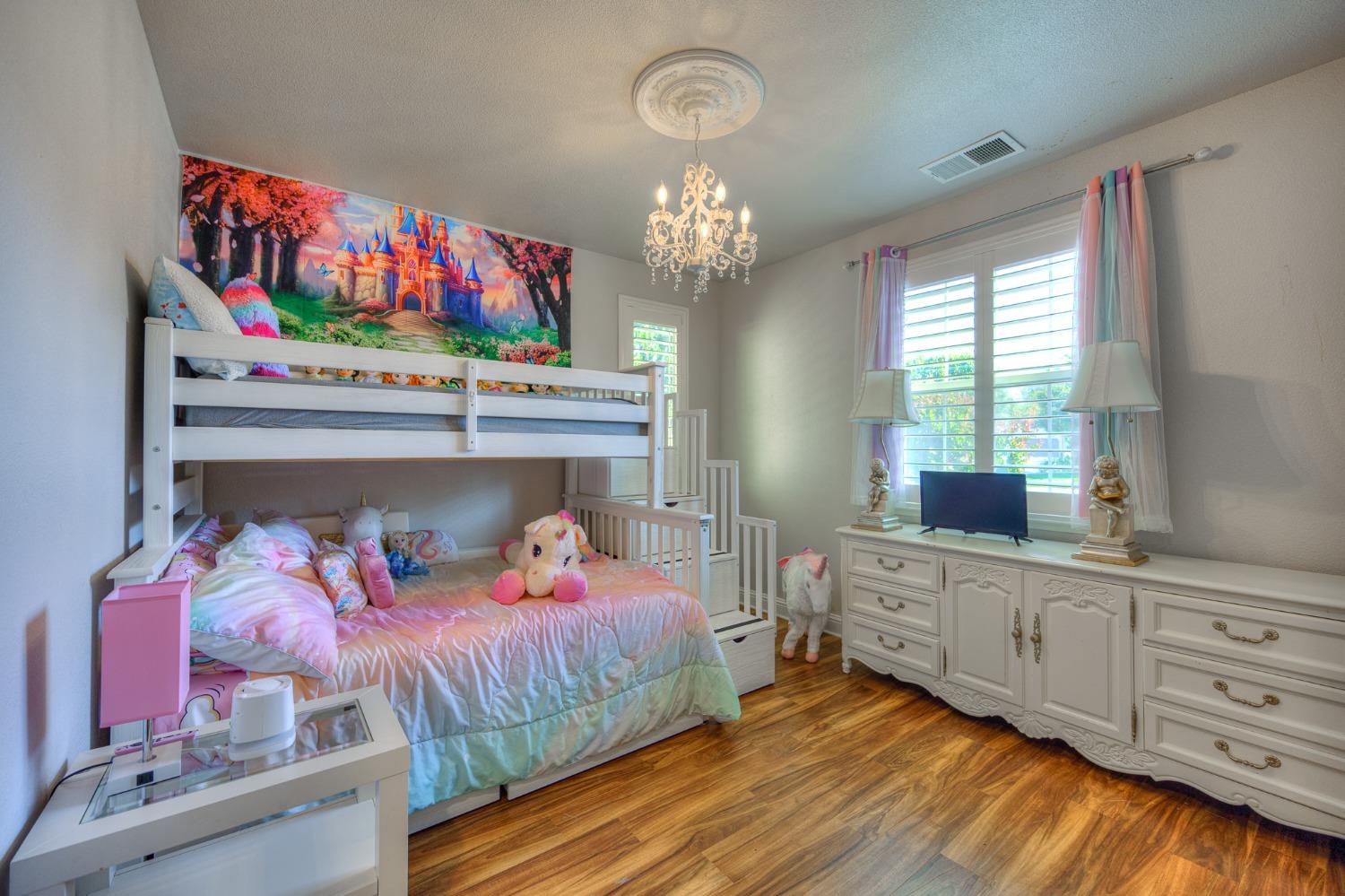 3731 Serena Avenue Clovis, CA 93619 - Photo 28 of 54 a bedroom with a bed and a chandelier