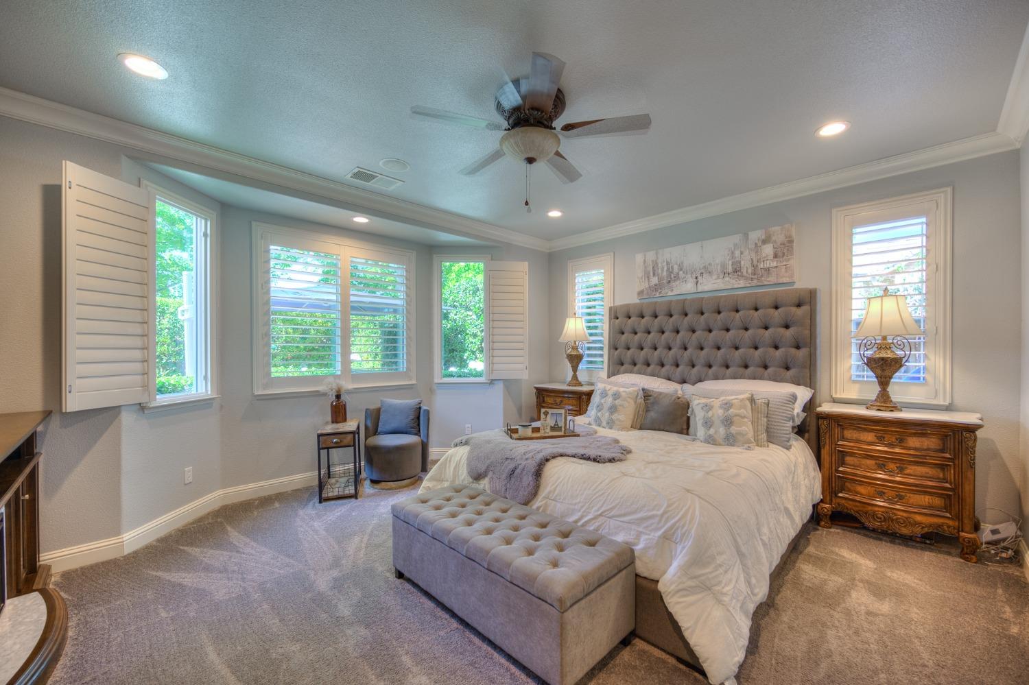 3731 Serena Avenue Clovis, CA 93619 - Photo 30 of 54 a bedroom with double bed windows and a chandelier