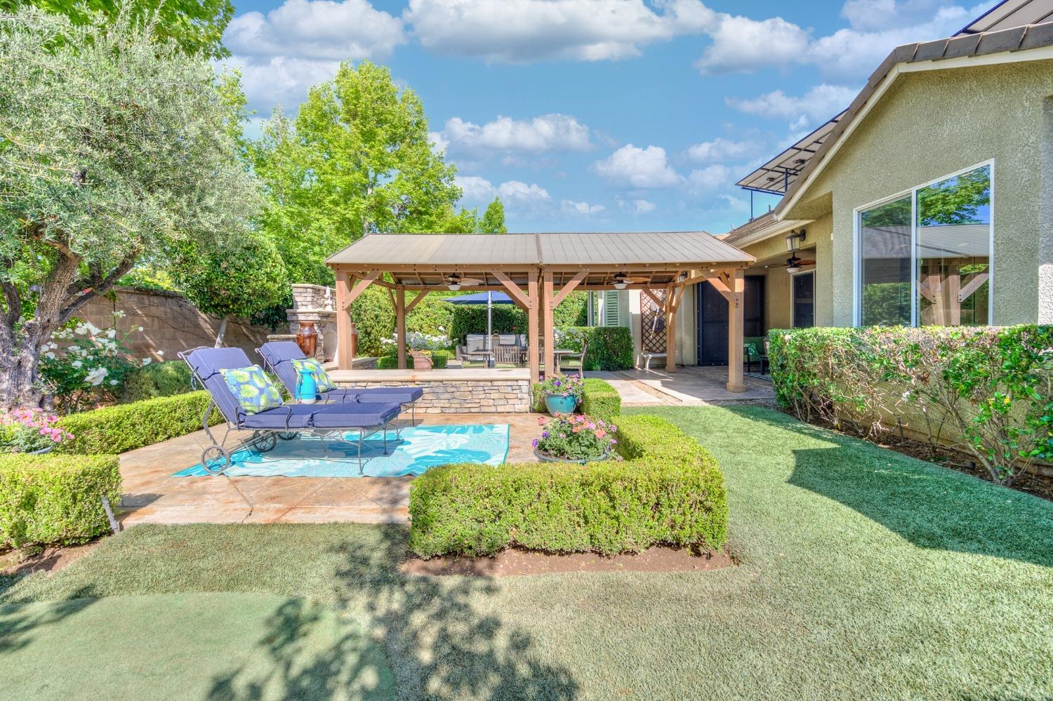 3731 Serena Avenue Clovis, CA 93619 - Photo 37 of 54 a view of a patio with couches table and chairs under an umbrella