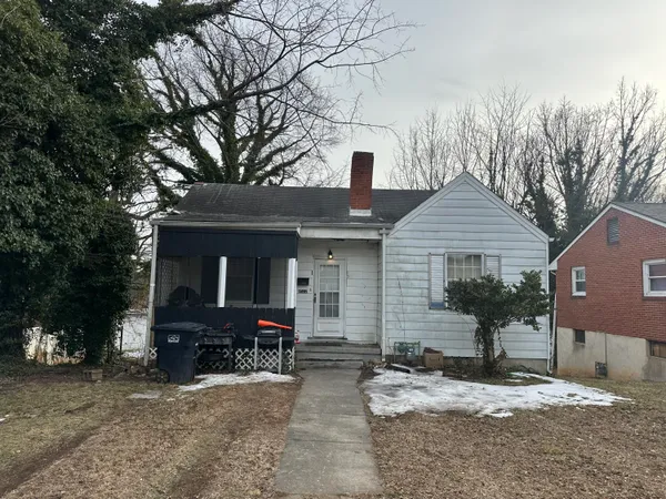 a view of a house with yard and trees in the background