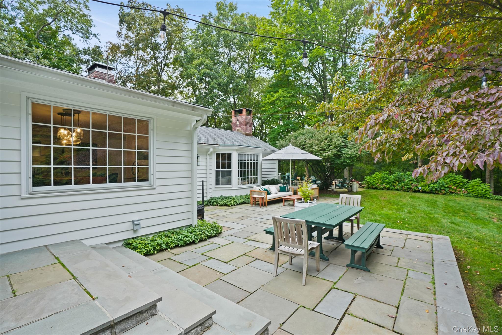 43 Croton Lake Road Katonah, NY 10536 - Photo 22 of 26 a view of a house with backyard sitting area and garden