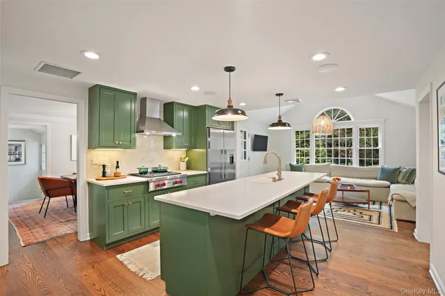 a kitchen with stainless steel appliances a table and chairs in it