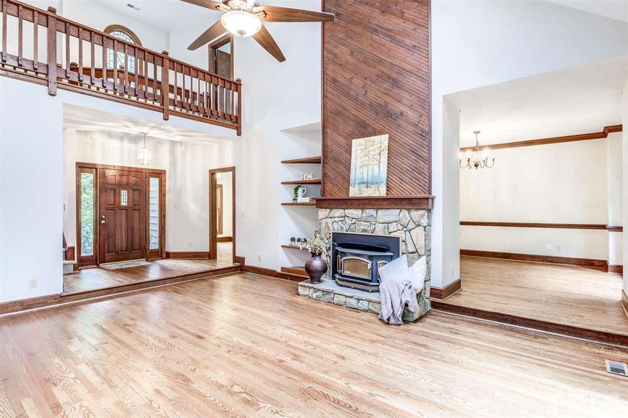 7604 Glenharden Drive Raleigh, NC 27613 - Photo 6 of 30 a view of a livingroom with wooden floor a fireplace and window
