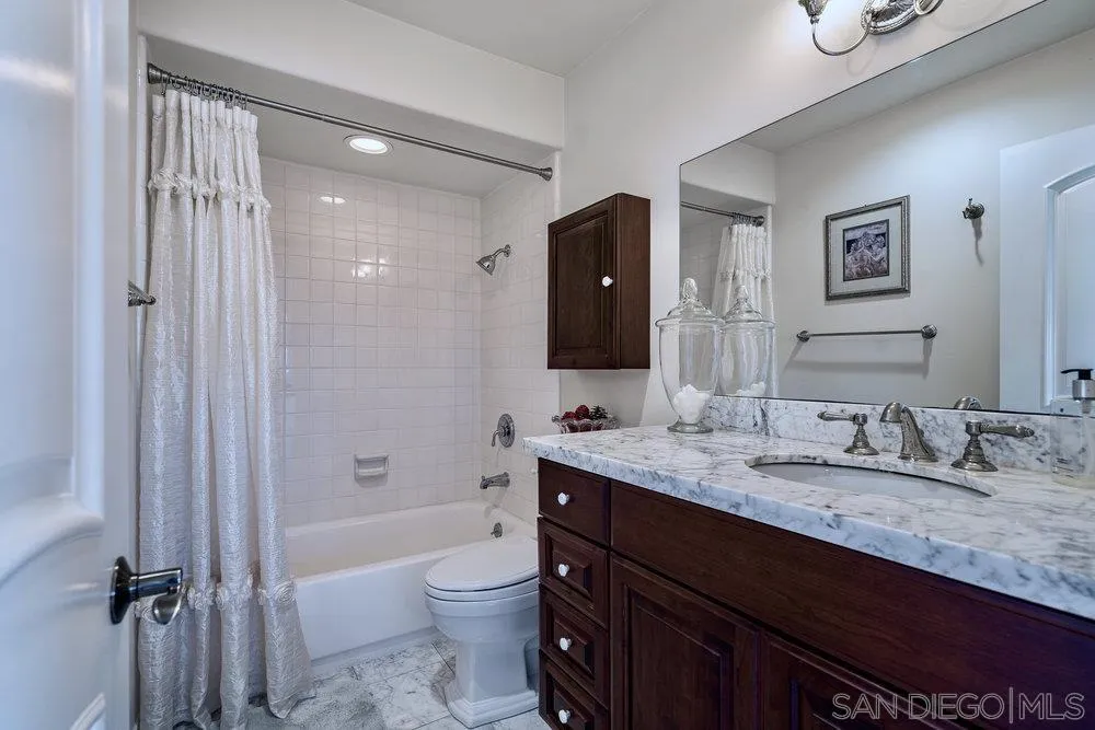 4 GingerTree Lane Coronado, CA 92118 - Photo 30 of 54 a bathroom with a granite countertop sink toilet a mirror a vanity and shower