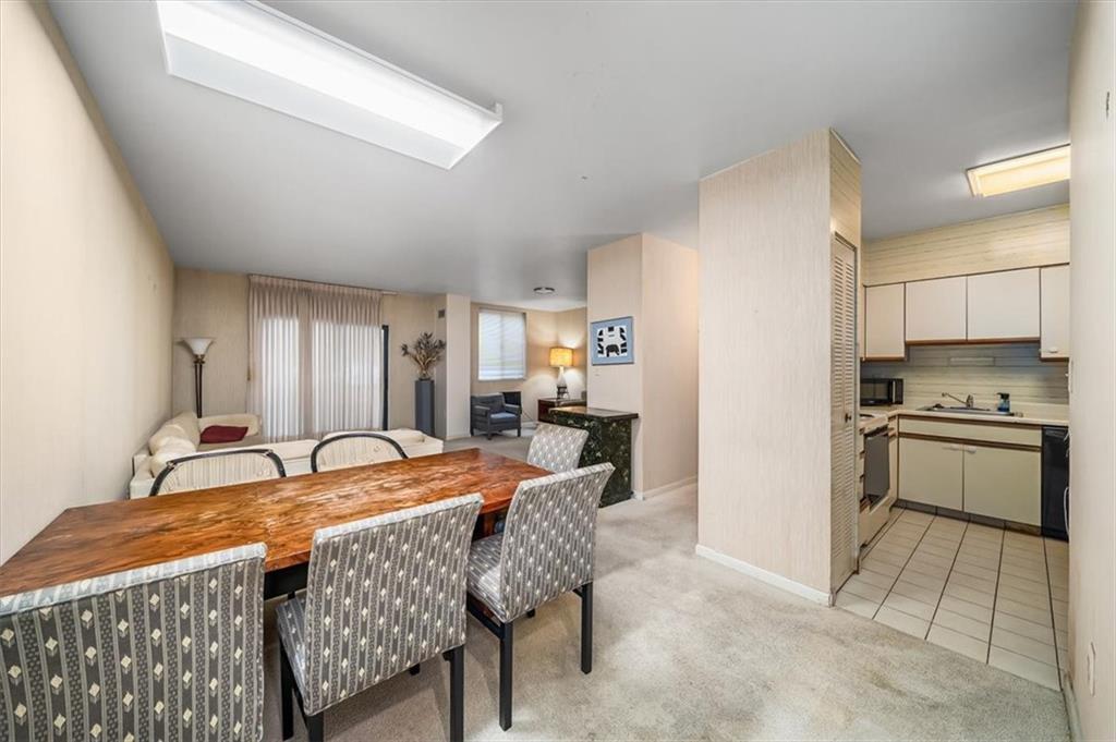 5715 Beacon Street, Unit 108 Pittsburgh, PA 15217 - Photo 9 of 27 a dining hall with stainless steel appliances granite countertop a stove a refrigerator a oven with white cabinets and chairs