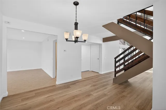 a view of a hallway with wooden floor and stairs