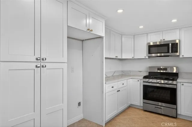 a view of a living room with furniture and a refrigerator