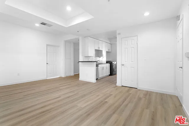 a view of a kitchen with wooden floor and a sink