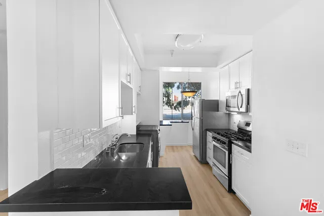 a kitchen with stainless steel appliances a sink a stove and a refrigerator