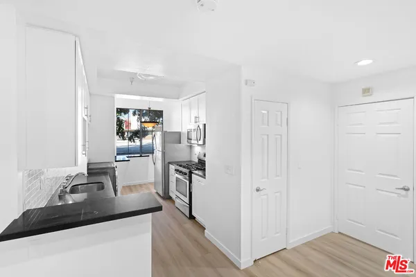 a kitchen with kitchen island a sink stove and refrigerator