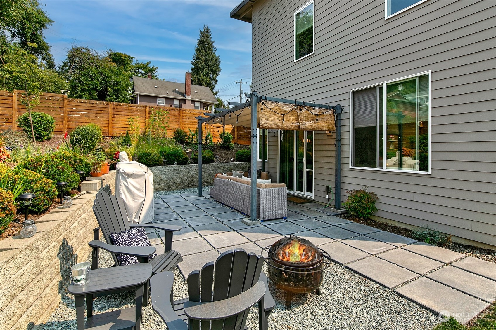 5136 South Creston Street Seattle, WA 98178 - Photo 8 of 27 a view of a patio with table and chairs potted plants and floor to ceiling window and wooden fence