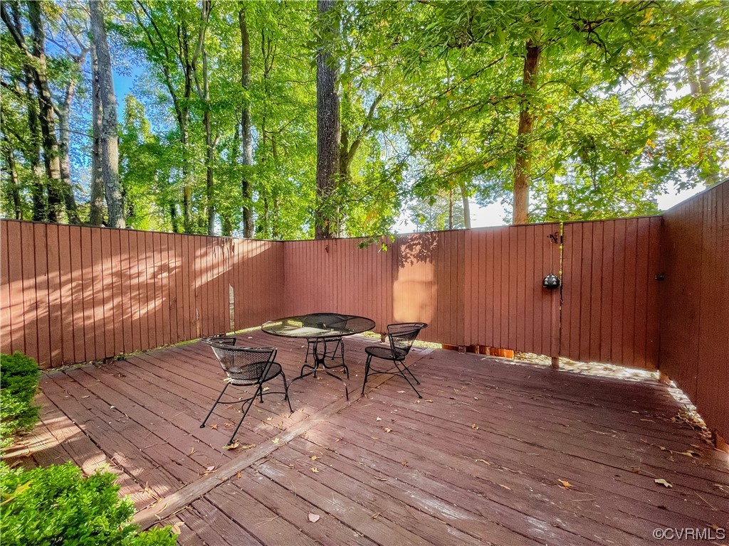 11601 East Briar Patch Drive Midlothian, VA 23113 - Photo 48 of 50 a backyard of a house with table and chairs wooden fence and large trees