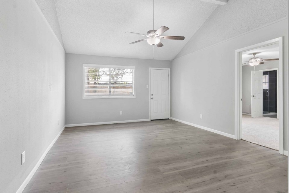 7403 Strawbridge Lane Houston, TX 77040 - Photo 4 of 22 an empty room with wooden floor and windows
