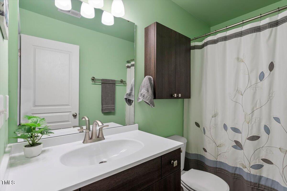 7759 Winners Edge Street Raleigh, NC 27617 - Photo 21 of 31 a bathroom with a sink vanity mirror and toilet