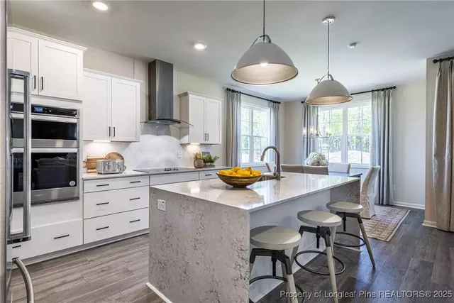a kitchen with stainless steel appliances granite countertop a stove a sink and a wooden floors