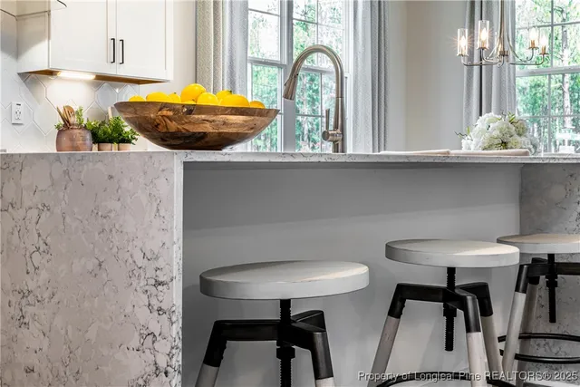 a kitchen with stainless steel appliances a table and chairs in it