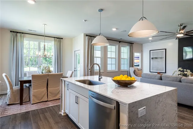 a kitchen with stainless steel appliances granite countertop a sink and a wooden floors
