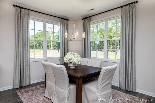 a view of a dining room with furniture a chandelier and wooden floor