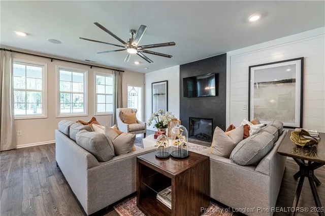 a living room with furniture a ceiling fan and a window