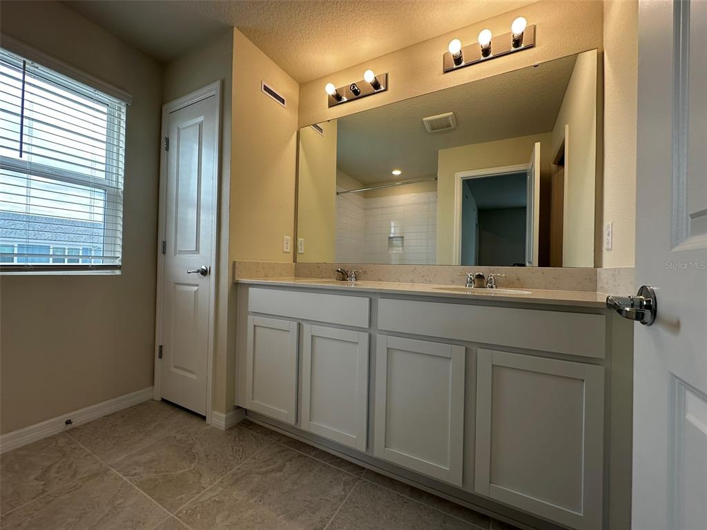 4806 Sparkling Shell Avenue Kissimmee, FL 34746 - Photo 11 of 19 a bathroom with a double vanity sink and mirror