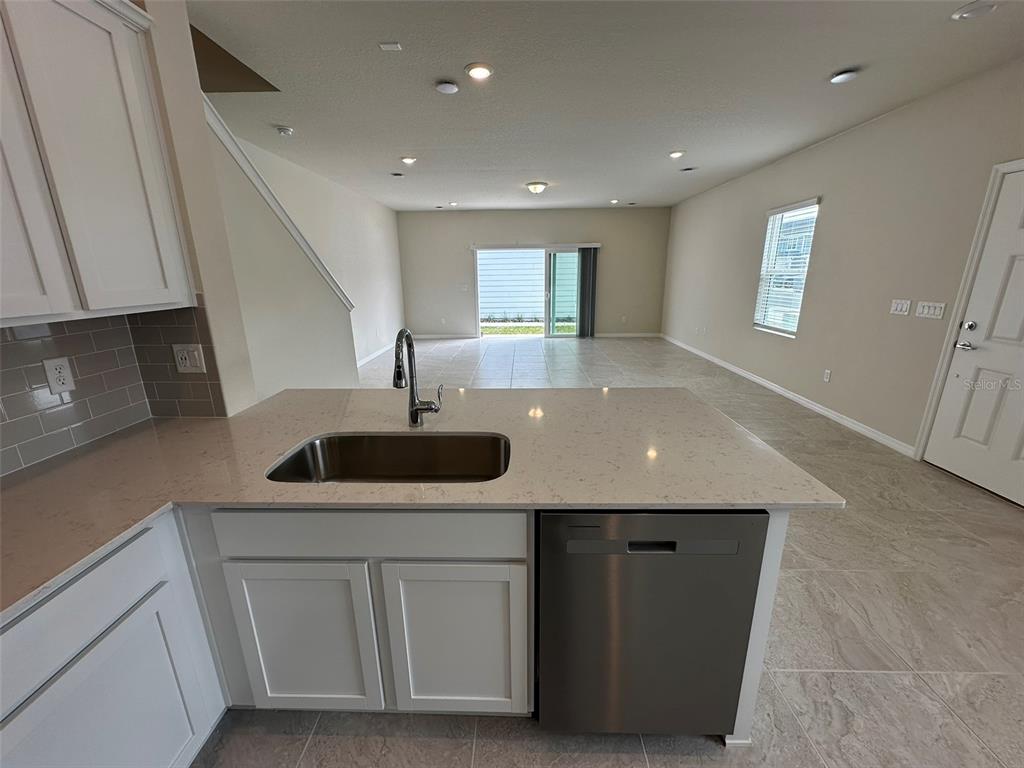 4806 Sparkling Shell Avenue Kissimmee, FL 34746 - Photo 5 of 19 a kitchen with a sink stainless steel appliances and cabinets