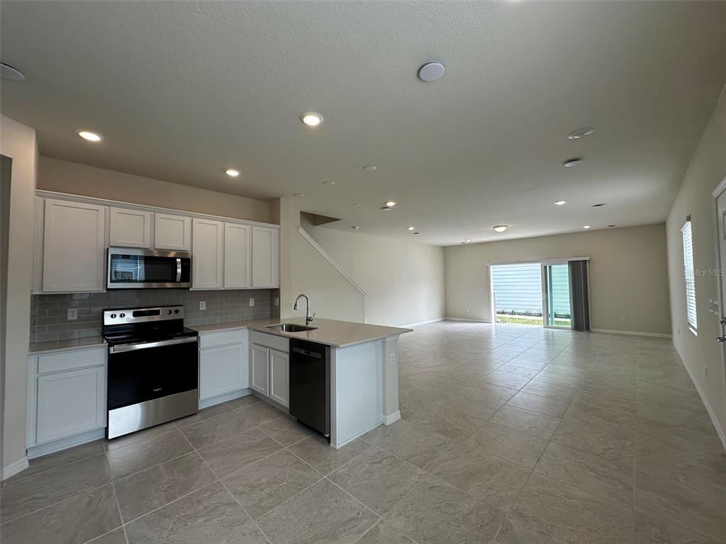 4806 Sparkling Shell Avenue Kissimmee, FL 34746 - Photo 6 of 19 a kitchen with stainless steel appliances granite countertop a refrigerator stove top oven and sink